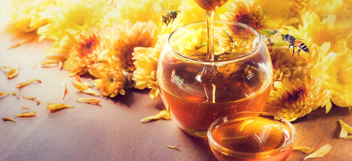 Honey,In,Glass,Jar,With,Bee,Flying,And,Flowers,On